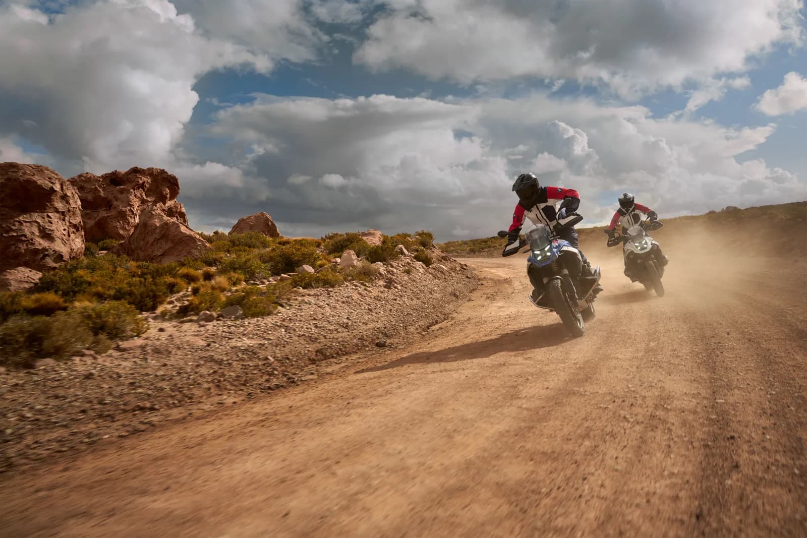 Two BMW R 1300 GS riders on a gravel road